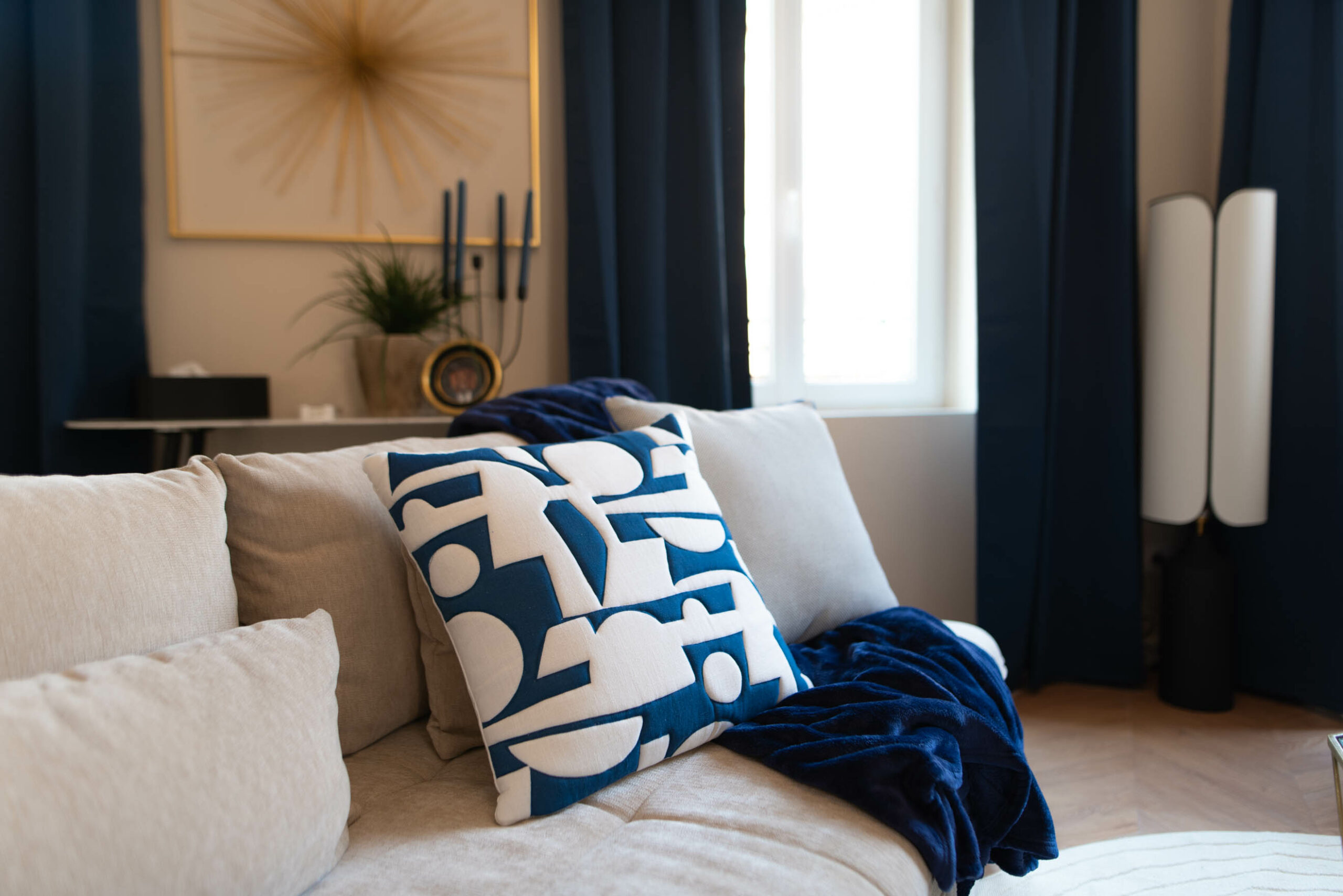 Coussin décoratif bleu et blanc sur le canapé gris